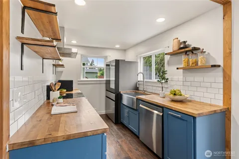 a kitchen with stainless steel appliances granite countertop a sink stove and refrigerator