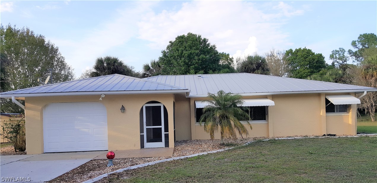 23971 North River Road Alva, FL 33920 - Photo 1 of 21 a front view of a house with a garden