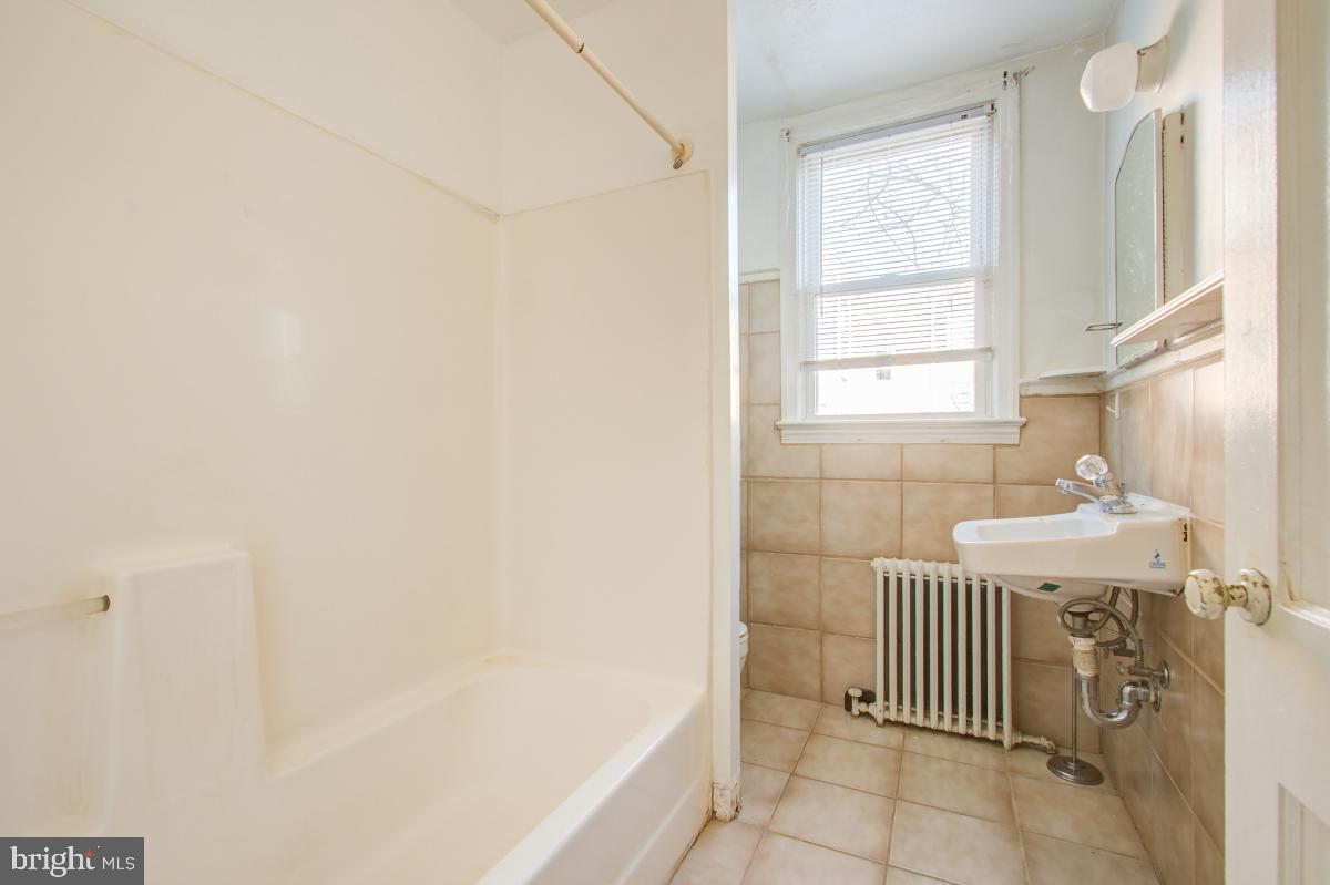 6120 41st Avenue, Unit 1 Hyattsville, MD 20782 - Photo 25 of 28 a bathroom with a sink and a bathtub