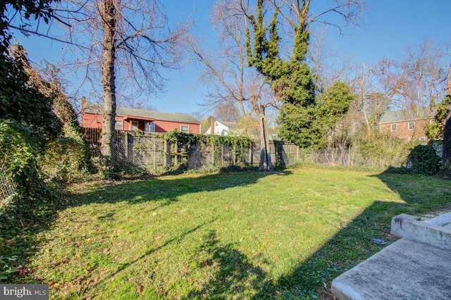 a front view of house with yard and trees in the background