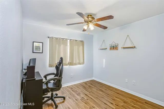 a view of a workspace with wooden floor and a window