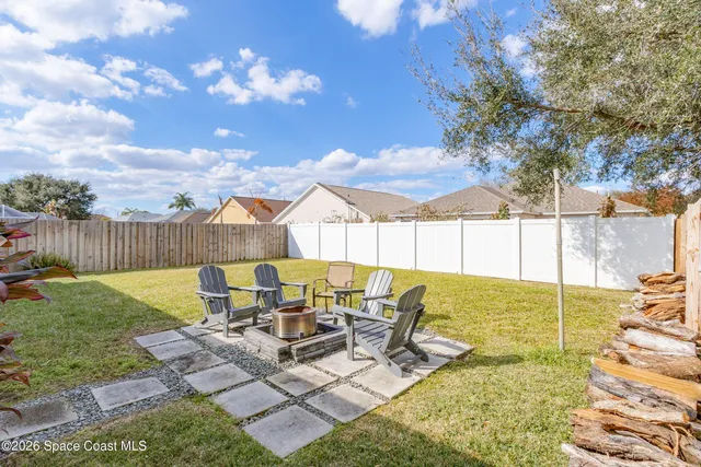 a view of a patio with table and chairs with wooden fence