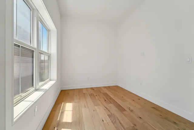a view of a room with wooden floor and a window