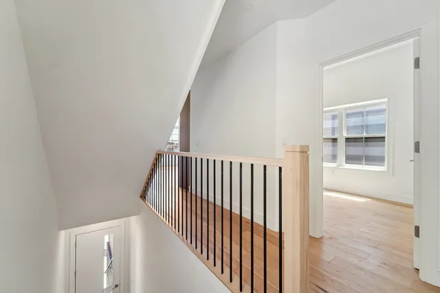 a view of a hallway with wooden floor and windows