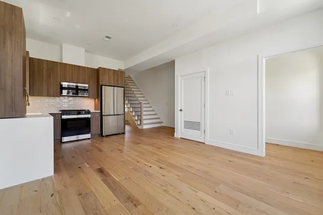 a view of kitchen with wooden floor and electronic appliances