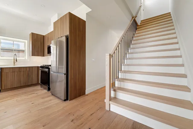 a kitchen with stainless steel appliances a refrigerator and wooden floor