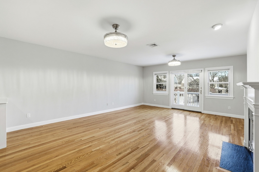 74 Branch Street, Unit 15 Scituate, MA 02066 - Photo 9 of 26 an empty room with wooden floor and windows
