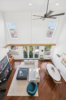 a kitchen with stainless steel appliances granite countertop a refrigerator a oven a stove and a dining table with wooden floor