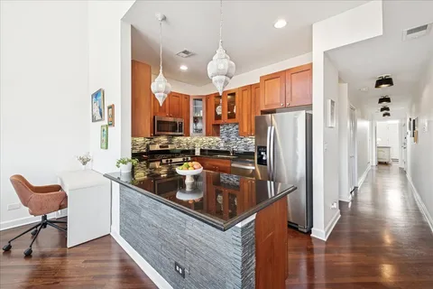 a kitchen with stainless steel appliances granite countertop a sink refrigerator stove and microwave