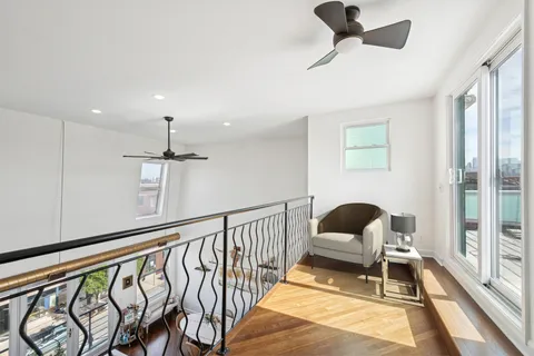 a view of a balcony with two chairs and a potted plant