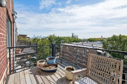 a view of roof deck with a barbeque and wooden stairs