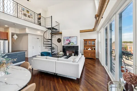 a living room with furniture kitchen view and a large window