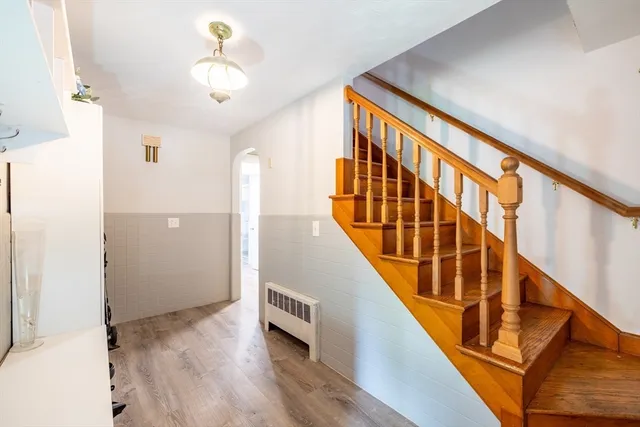 a view of staircase with wooden floor and fan