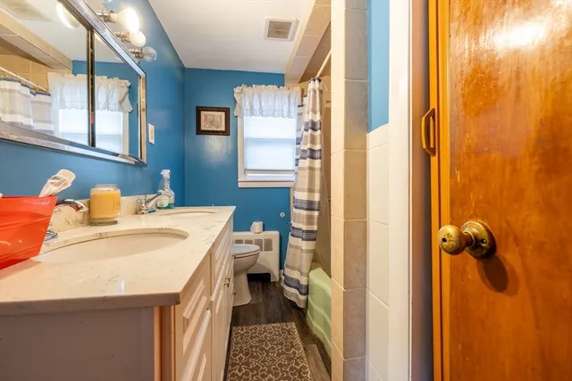 a bathroom with a sink and mirror with shower