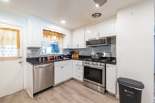 a kitchen with stainless steel appliances granite countertop a stove sink and microwave