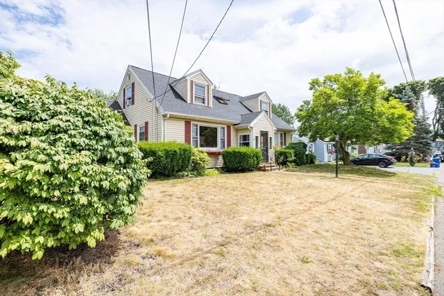 a front view of a house with a yard and trees