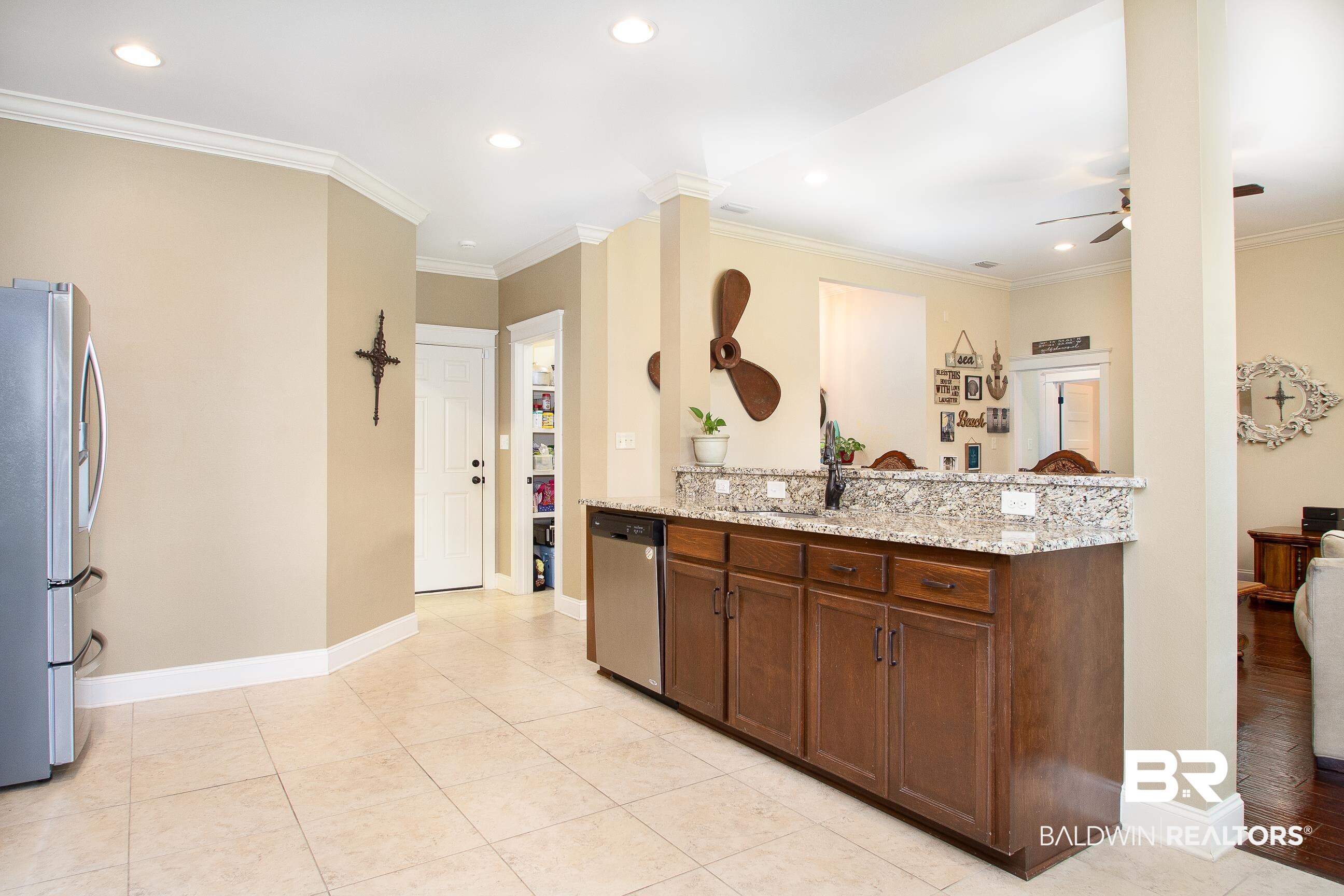 8625 Rosedown Lane Daphne, AL 36526 - Photo 8 of 29 Kitchen featuring light stone counters, kitchen peninsula, stainless steel appliances, ceiling fan, and ornamental molding