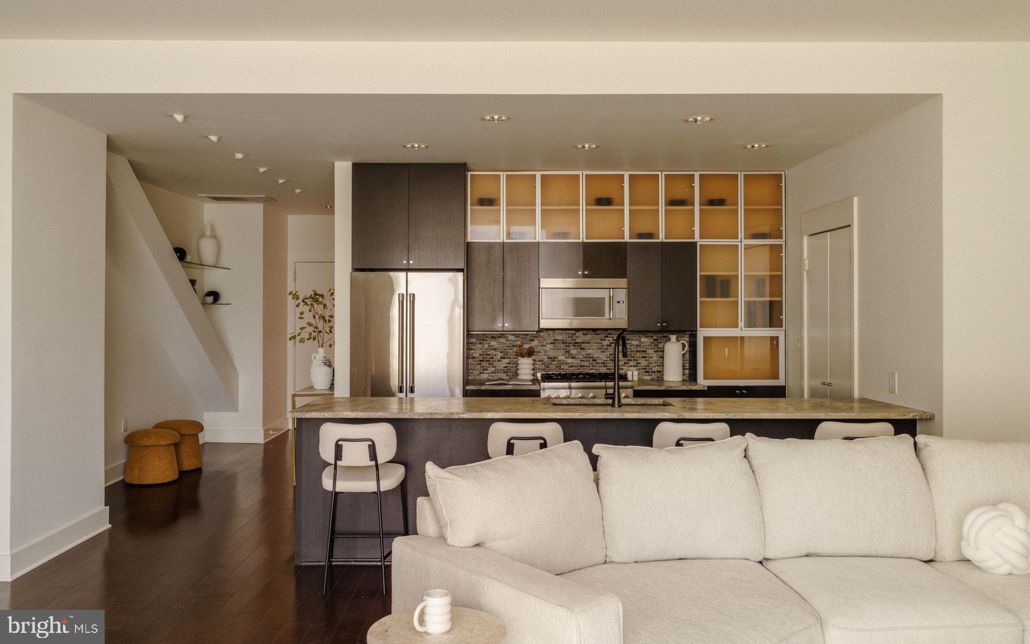 1111 Locust Street, Unit PH10D Philadelphia, PA 19107 - Photo 30 of 31 a living room with couches and kitchen view with wooden floor
