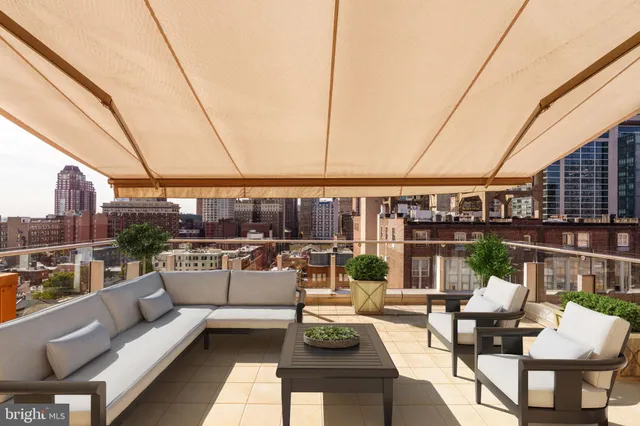 a view of a roof deck with couches and potted plants