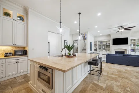 a view of kitchen with kitchen island a sink wooden floor and living room view