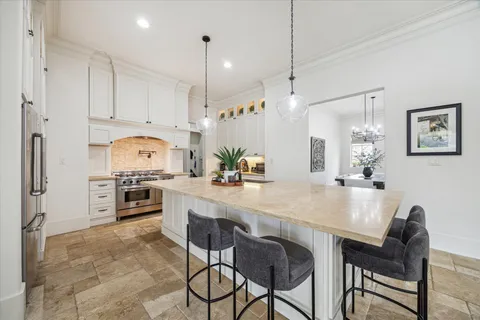 a kitchen with kitchen island granite countertop a table and chairs in it