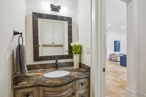 a en suite bathroom with a granite countertop sink and a mirror