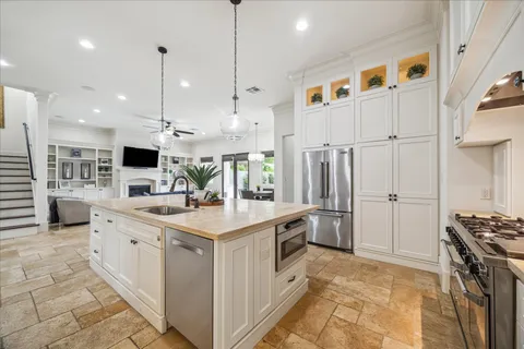 a kitchen with kitchen island a stove a sink and a refrigerator