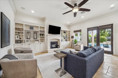 a living room with furniture a fireplace a flat screen tv and a large window
