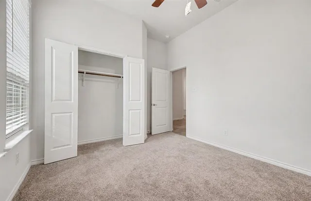 an empty room with windows and closet