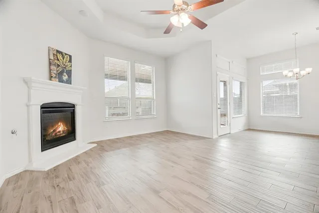 wooden floor fireplace and windows in an empty room