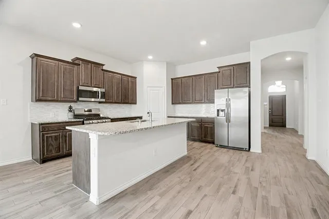 a kitchen with stainless steel appliances granite countertop a refrigerator stove and microwave