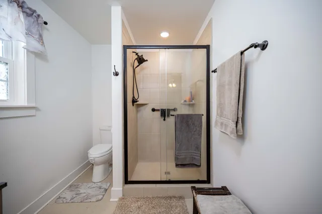 a bathroom with a granite countertop shower a toilet and sink