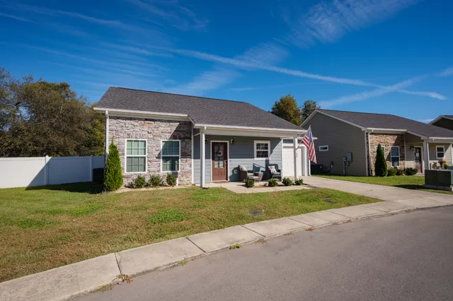 a view of a house with a yard and porch