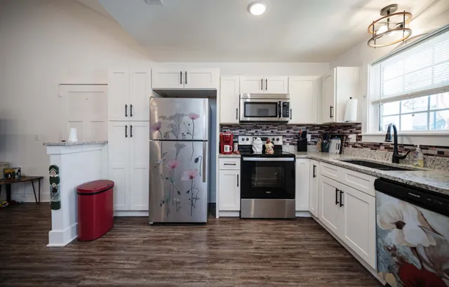 a kitchen with stainless steel appliances granite countertop a refrigerator sink and cabinets