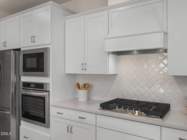 a living room with furniture kitchen view and a chandelier