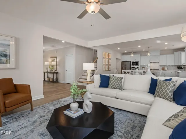 a living room with furniture a large window and a table