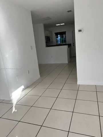 a view of a refrigerator a sink and dishwasher with white cabinets