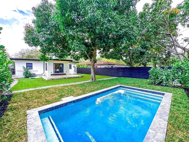 a view of house with backyard and outdoor seating