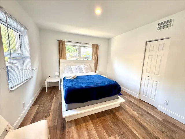 a bedroom with a bed and a large window