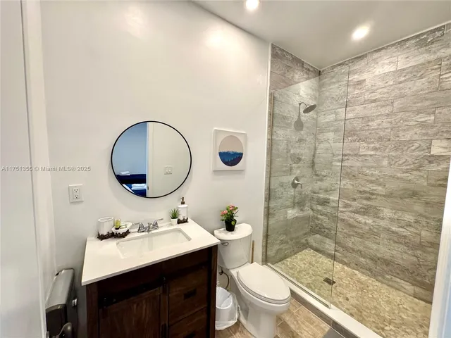a bathroom with a sink toilet a mirror and shower