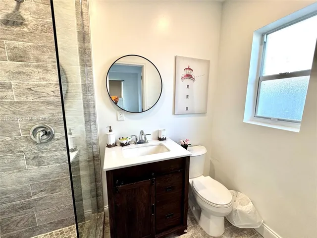 a bathroom with a toilet sink vanity and mirror