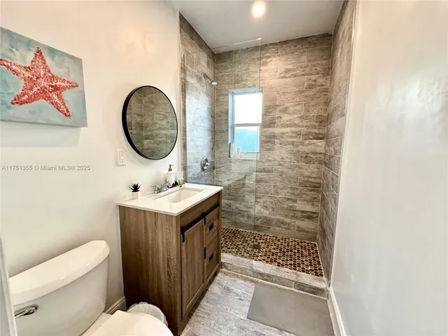a bathroom with a sink mirror vanity and toilet