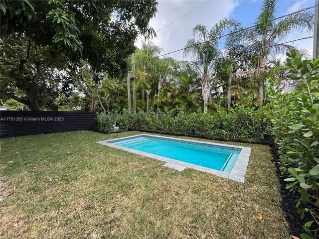 a view of pool with a yard