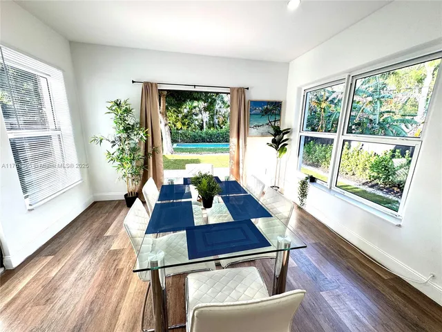 a living room with a couch a large window with wooden floor