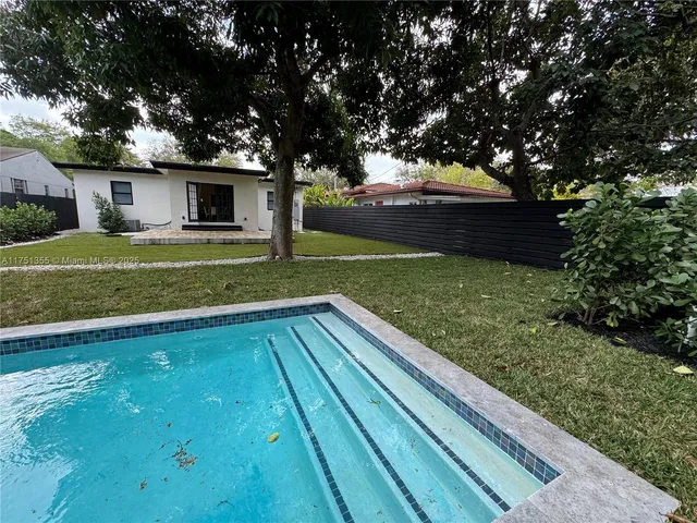a view of backyard with swimming pool and outdoor seating