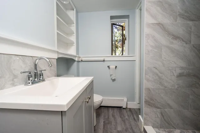 a bathroom with a sink a toilet and a mirror