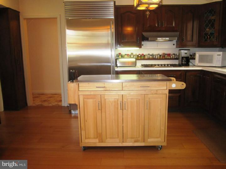 320 Gribbel Road Wyncote, PA 19095 - Photo 8 of 24 a kitchen with stainless steel appliances granite countertop a refrigerator a stove and a microwave with wooden floor