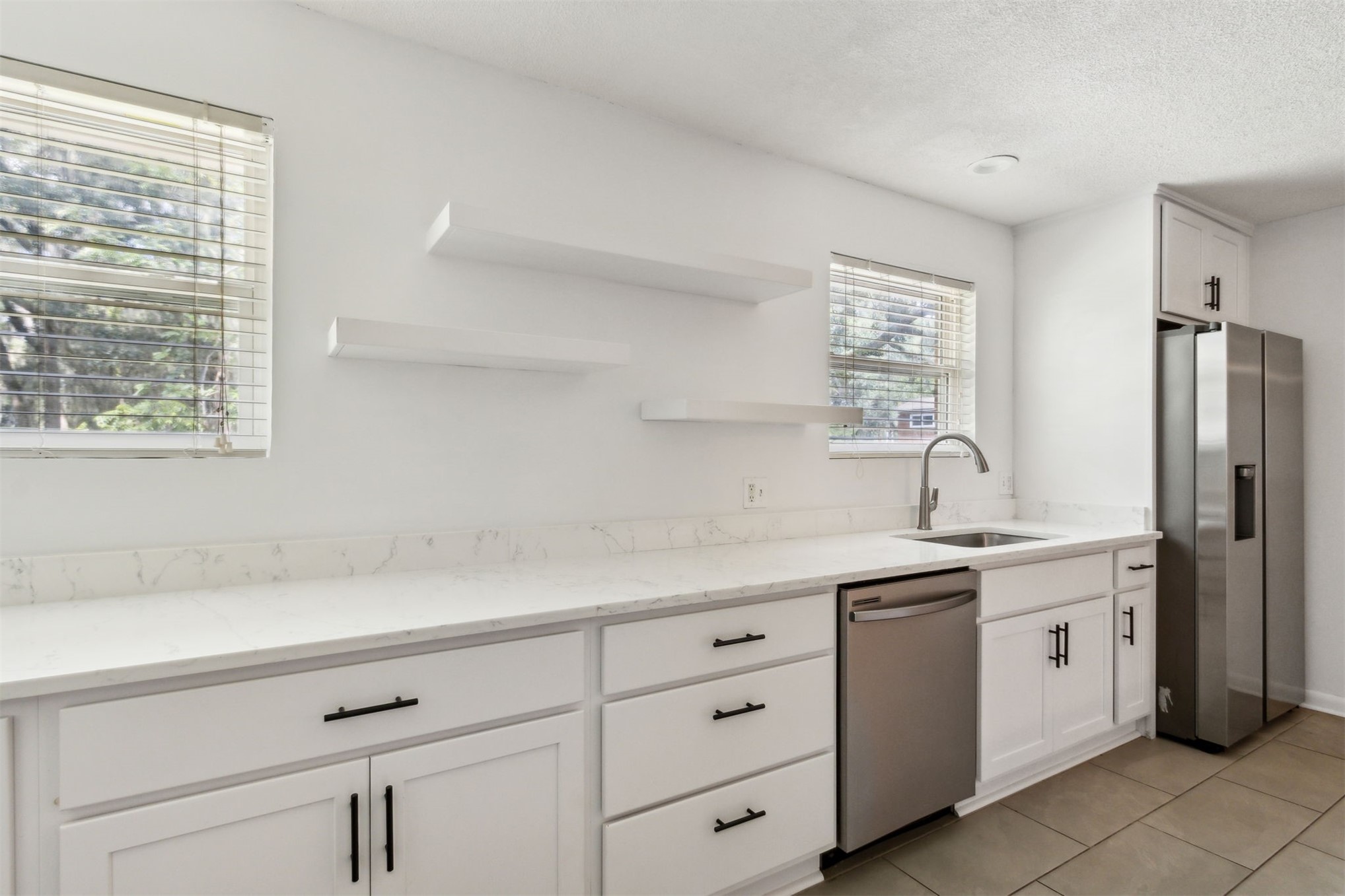2441 Amelia Road Fernandina Beach, FL 32034 - Photo 17 of 36 a kitchen with white cabinets and sink