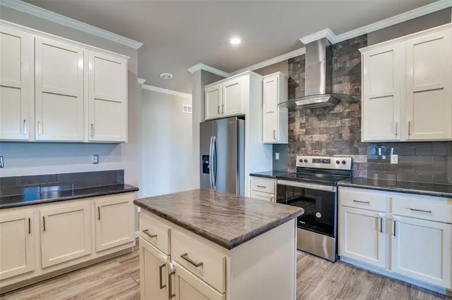 a kitchen with kitchen island granite countertop a sink appliances cabinets and counter space