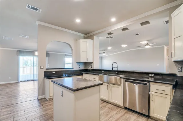 a kitchen with granite countertop a sink and cabinets
